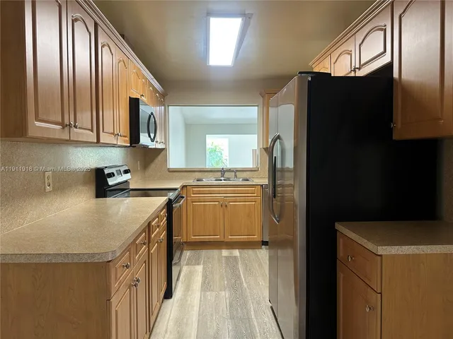 a kitchen with granite countertop a refrigerator and a sink