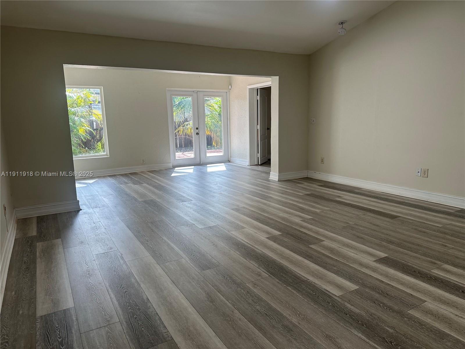 11354 Southwest 87th Terrace, Unit 11354 Miami, FL 33173 - Photo 3 of 25 an empty room with wooden floor and windows