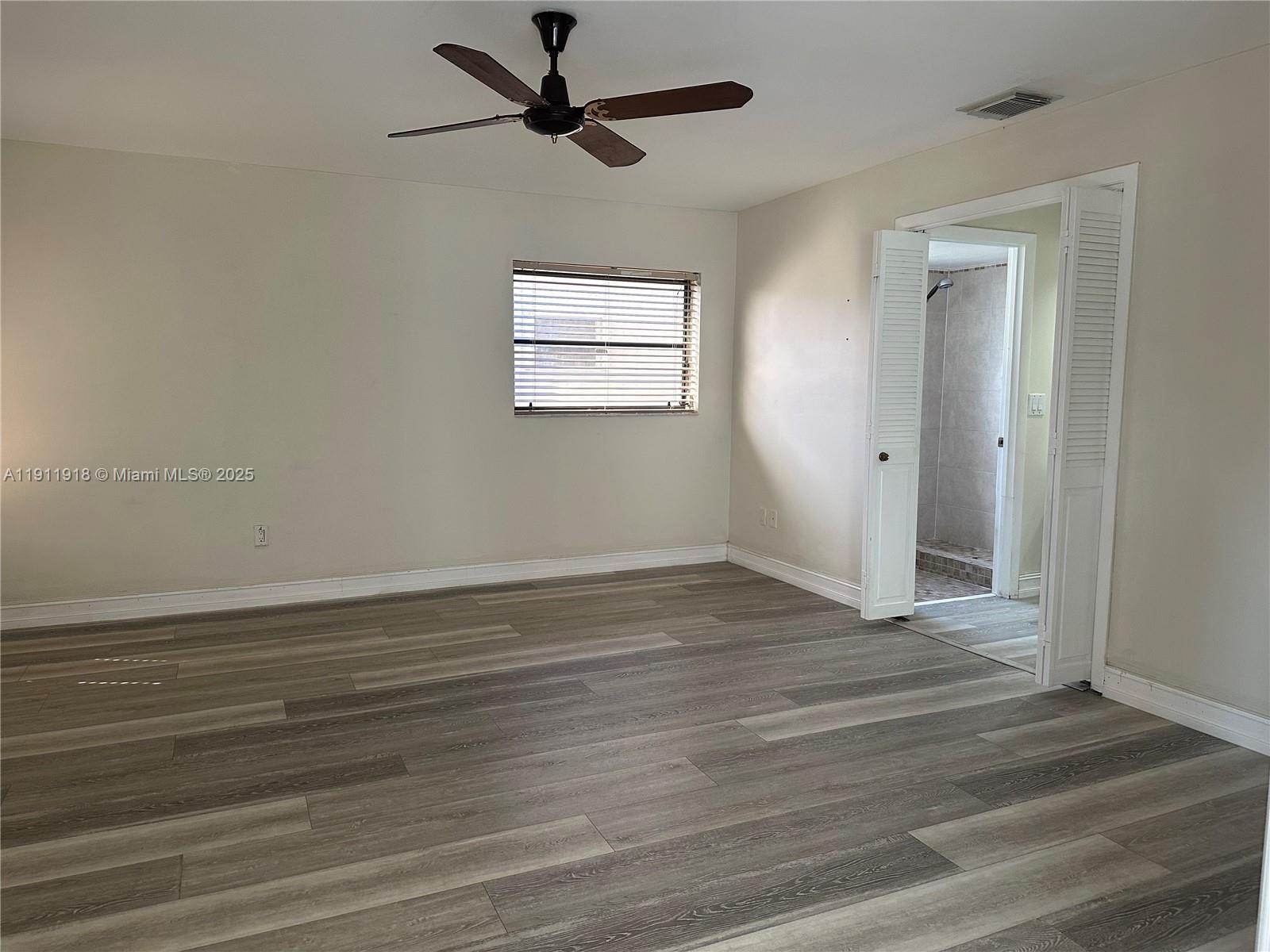 11354 Southwest 87th Terrace, Unit 11354 Miami, FL 33173 - Photo 8 of 25 a view of a room with wooden floor and a ceiling fan