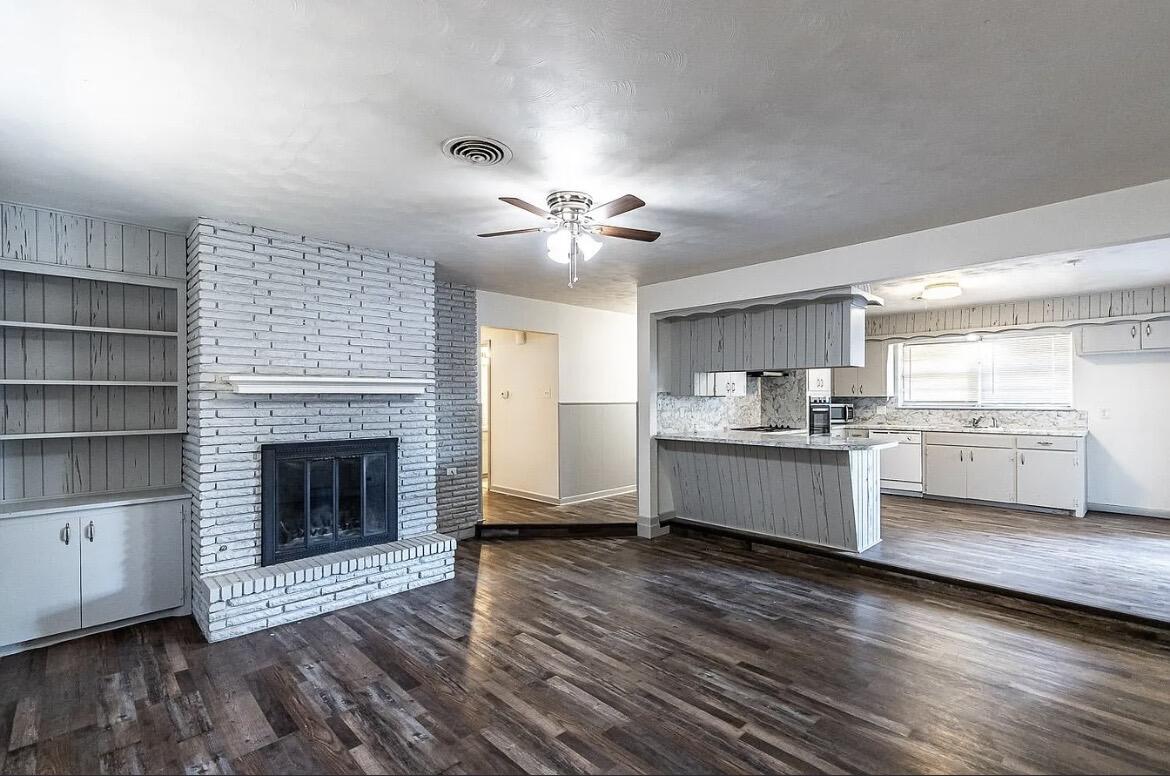 5426 43rd Street Lubbock, TX 79414 - Photo 1 of 27 a large kitchen with a stove fireplace and wooden floor