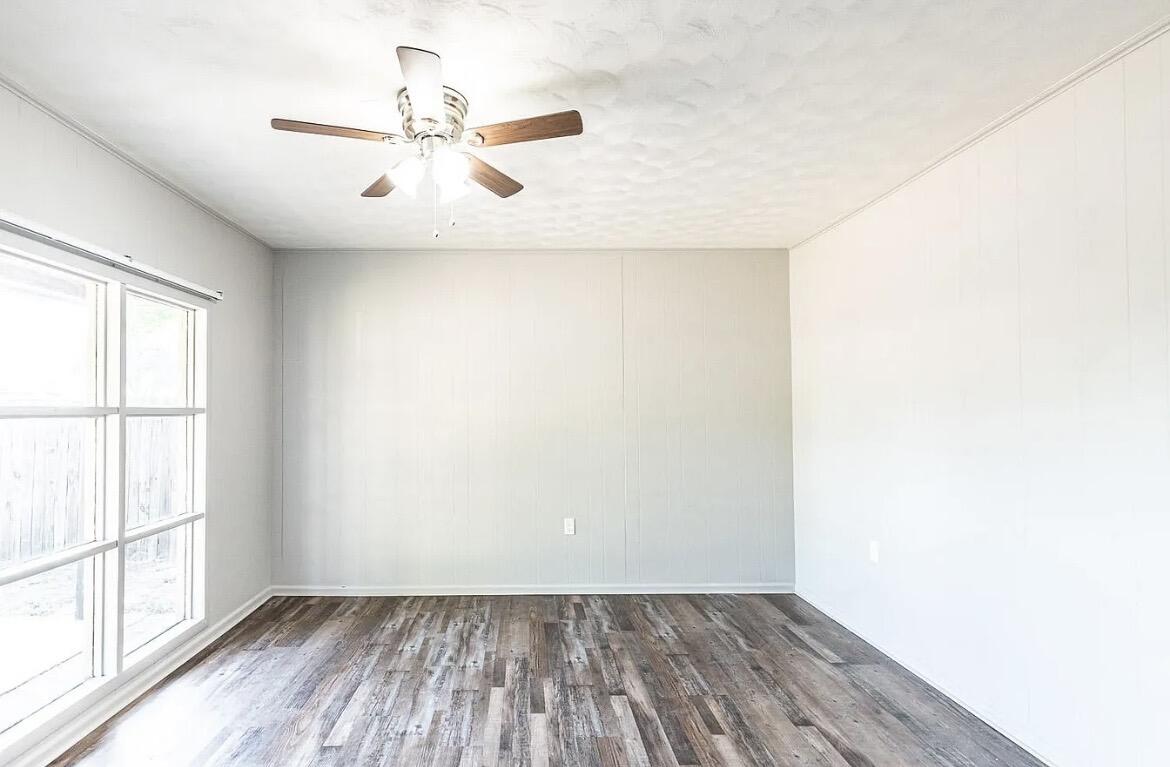 5426 43rd Street Lubbock, TX 79414 - Photo 15 of 27 an empty room with wooden floor fan and windows