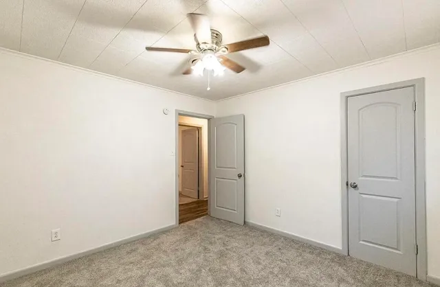 an empty room with a ceiling fan and a fan