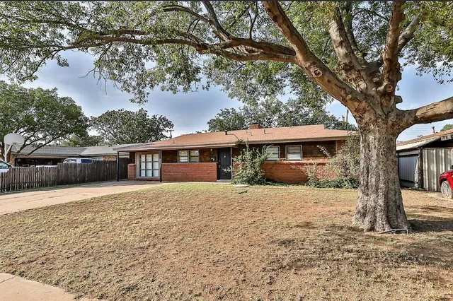 a front view of a house with a yard and trees