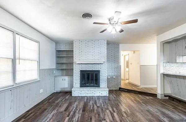 an empty room with windows and a fireplace