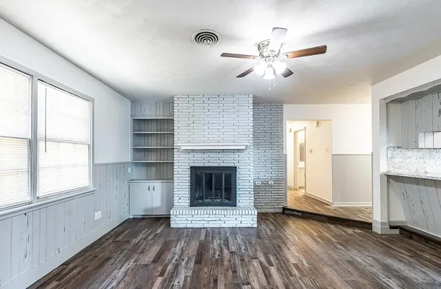 an empty room with windows and a fireplace