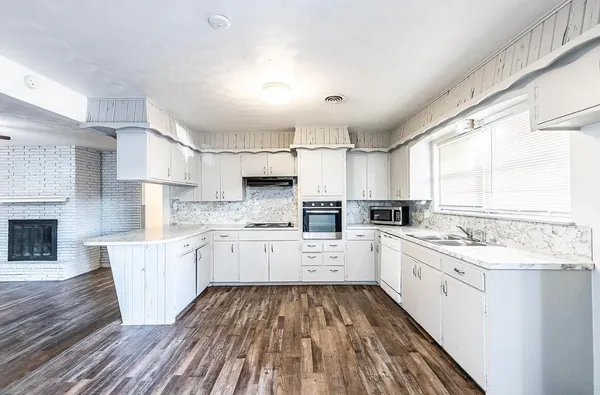 a kitchen with a sink window and cabinets