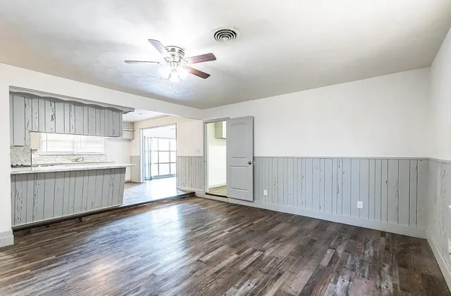 a view of a kitchen with wooden floor and a window
