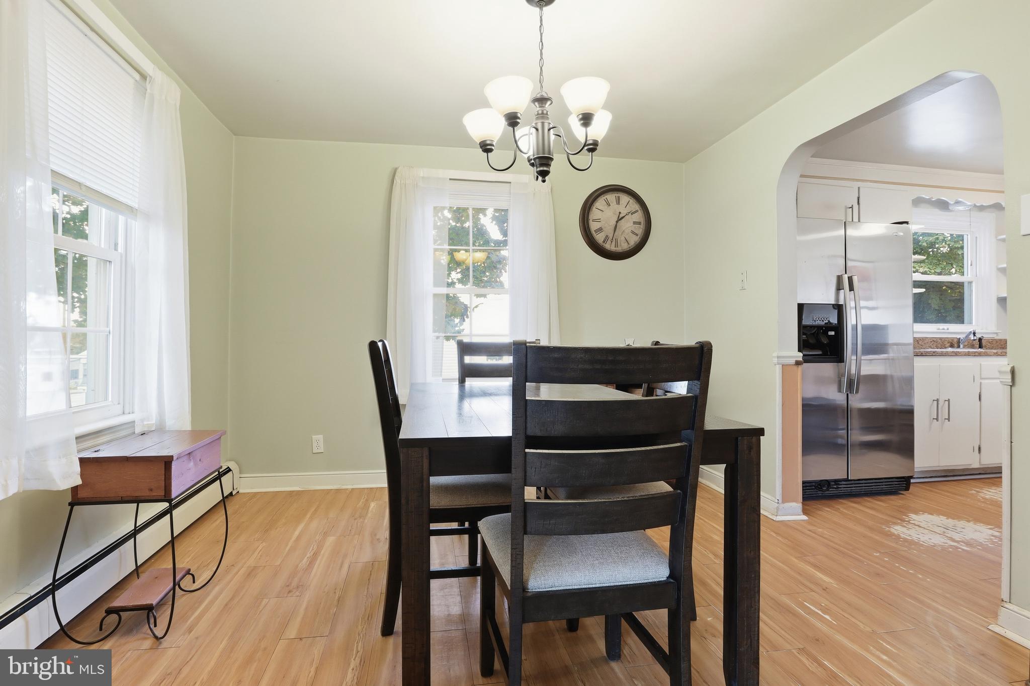 225 North Main Street Manchester, PA 17345 - Photo 7 of 53 a dining room with wooden floor a chandelier a wooden table and chairs