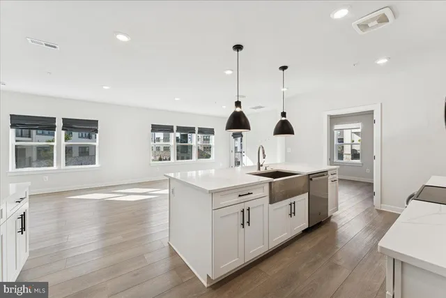 a large white kitchen with kitchen island stainless steel appliances a stove and a refrigerator