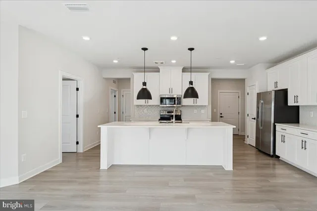 a kitchen with stainless steel appliances granite countertop a stove a sink a center island and a window