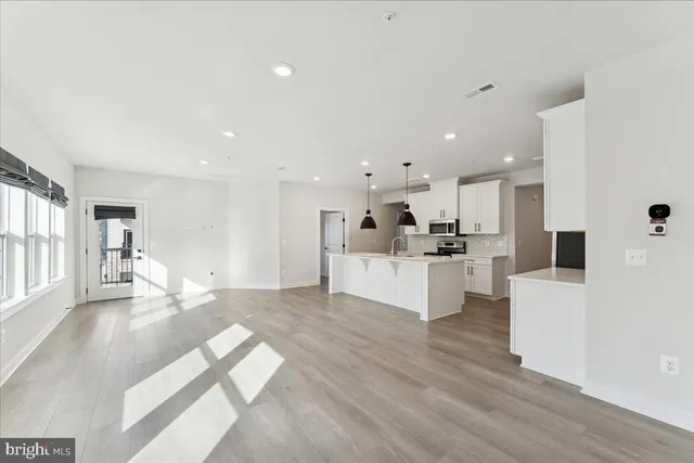 a open kitchen with stainless steel appliances granite countertop a sink a stove and a refrigerator