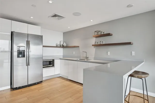 a kitchen with kitchen island a counter top space cabinets and stainless steel appliances