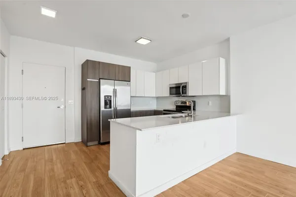 a kitchen with stainless steel appliances a refrigerator and a stove top oven