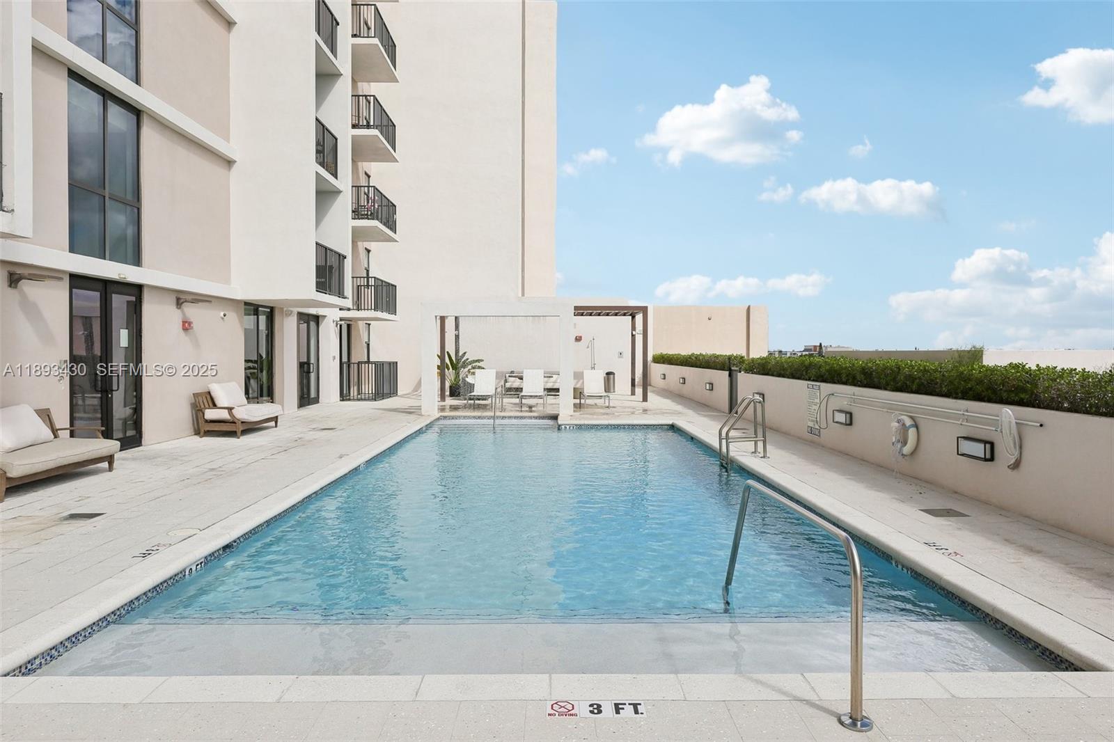 1501 Southwest 37th Avenue, Unit 708 Miami, FL 33145 - Photo 21 of 27 a view of a swimming pool with a lounge chair
