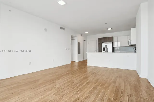 a view of a kitchen with wooden floor and electronic appliances