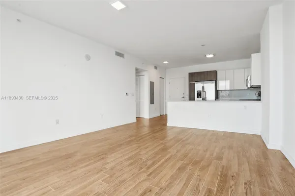 a view of a kitchen with wooden floor and electronic appliances