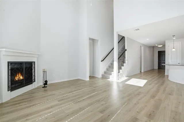 a view of an empty room with wooden floor fire place