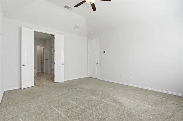 an empty room with a ceiling fan and window
