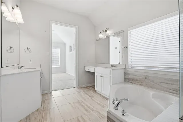a bathroom with a tub sink and mirror