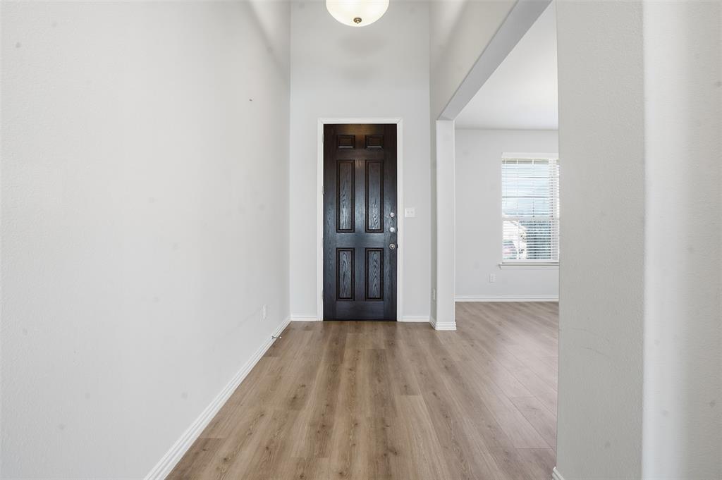 461 Windy Knoll Road Fort Worth, TX 76028 - Photo 3 of 30 a view of an empty room with wooden floor