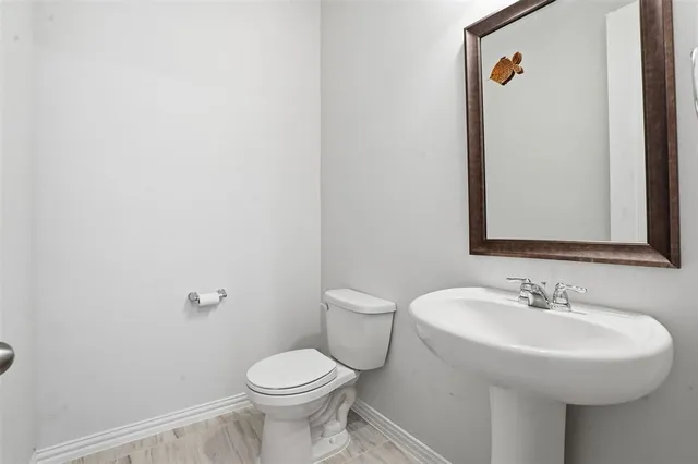 a bathroom with a sink toilet and a mirror