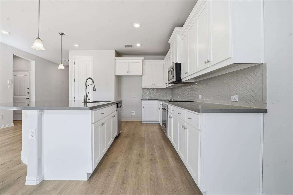 461 Windy Knoll Road Fort Worth, TX 76028 - Photo 7 of 30 a large kitchen with stainless steel appliances sink a microwave and cabinets