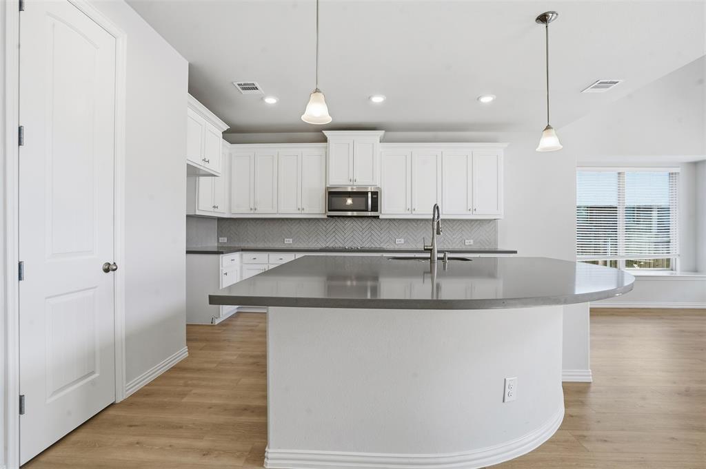 461 Windy Knoll Road Fort Worth, TX 76028 - Photo 8 of 30 a kitchen with kitchen island stainless steel appliances a sink and a stove