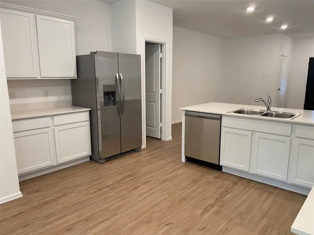 a kitchen with a refrigerator sink and cabinets