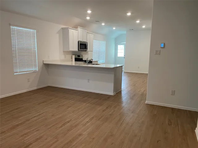 a view of kitchen with wooden floor and electronic appliances