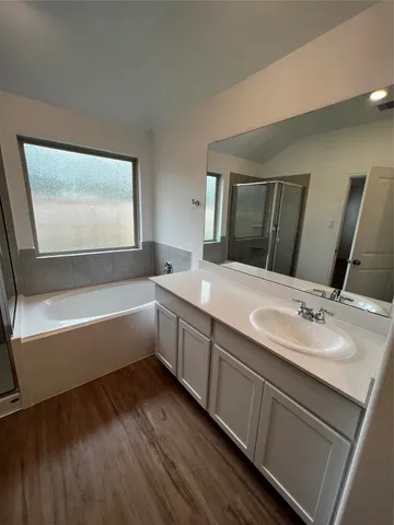 a bathroom with a granite countertop sink mirror and a bathtub