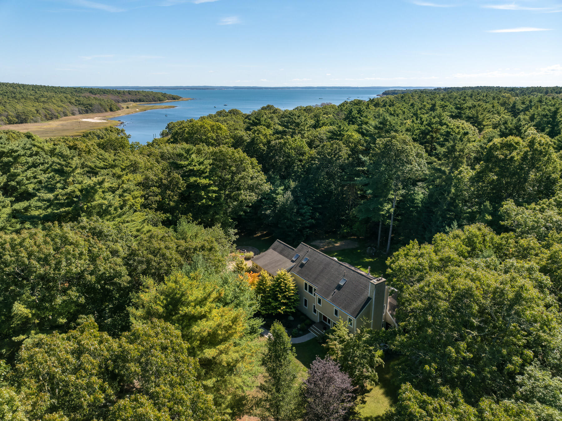 an aerial view of a houses with a yard and lake view