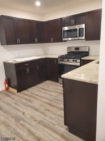 a kitchen with stainless steel appliances kitchen island granite countertop a stove and a microwave