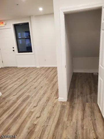 an empty room with wooden floor and mirror on wall