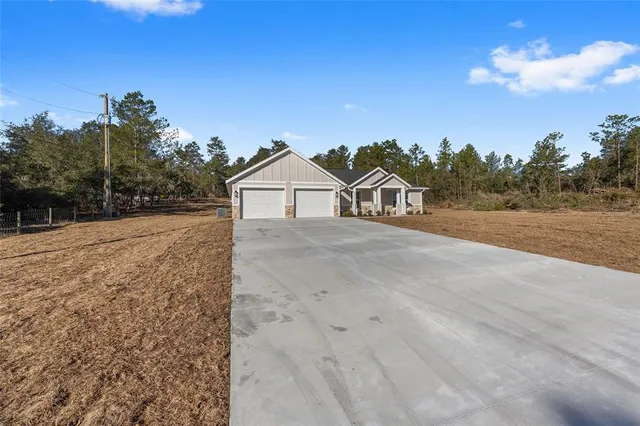 a view of a dry yard with wooden fence
