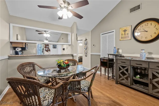 a view of a dining room and livingroom with furniture wooden floor a rug and a chandelier