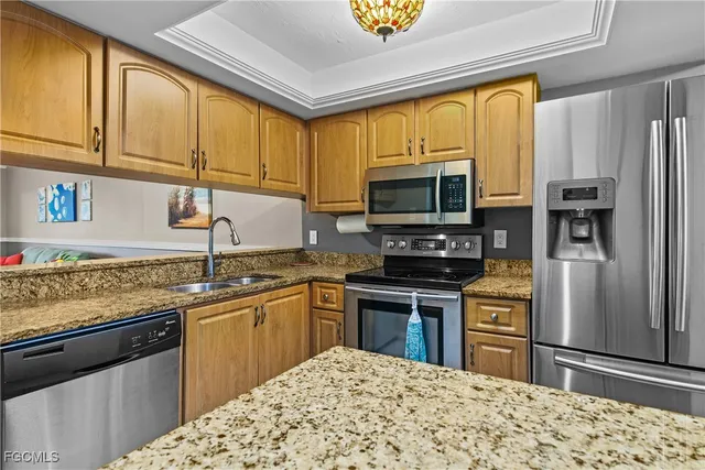 a kitchen with stainless steel appliances granite countertop a stove refrigerator sink and microwave