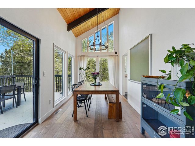 a dining room with furniture potted plants and wooden floor