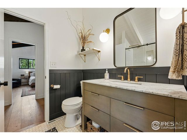 a en suite bathroom with a granite countertop toilet sink and mirror