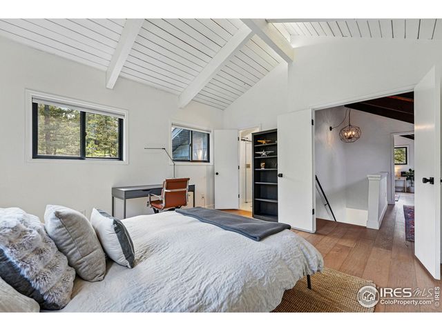 a bedroom with a bed and a view of living room