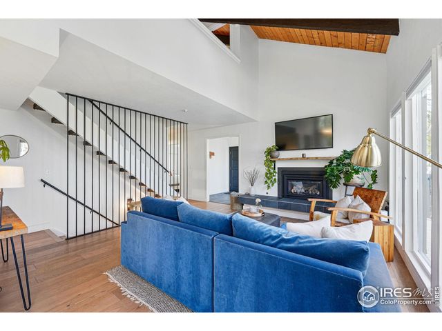 a living room with furniture a flat screen tv and a large window