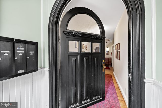 a view of staircase with lots of frames on wall and a window