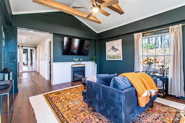 a living room with furniture a flat screen tv and a fireplace