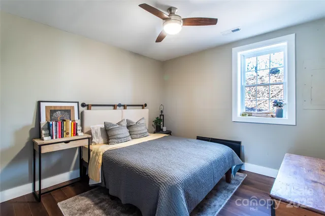 a bedroom with a bed and a painting on the wall