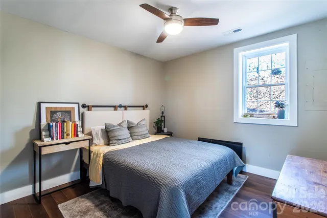 a bedroom with a bed and a painting on the wall