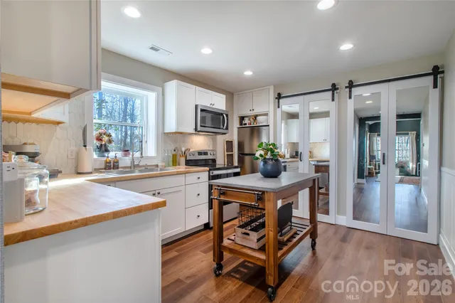 a kitchen with white cabinets and stainless steel appliances