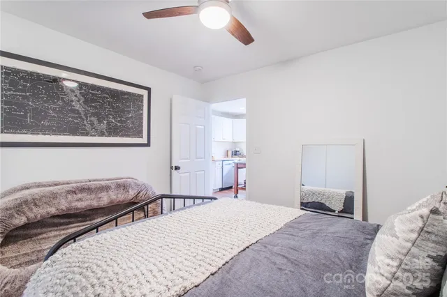 a bedroom with a large bed and a chandelier