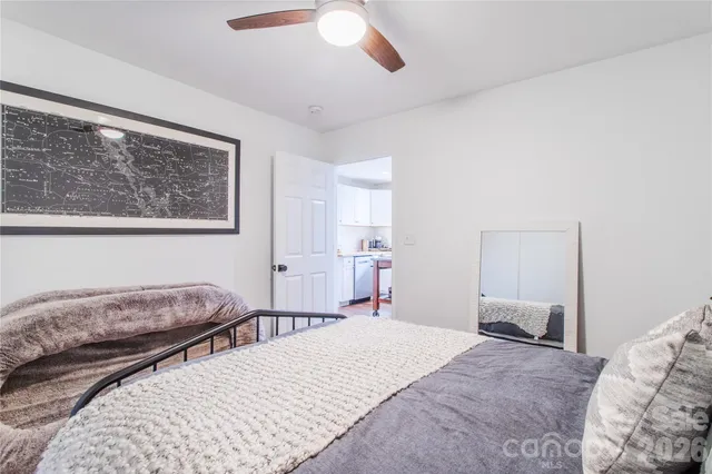 a bedroom with a large bed and a chandelier