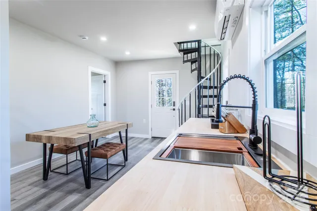 a living room with table a piano and wooden floor