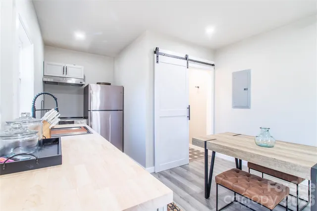 a spacious bedroom with a bed and wooden floor
