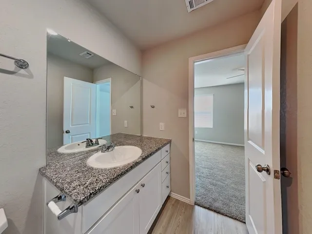 a bathroom with a granite countertop sink and a mirror